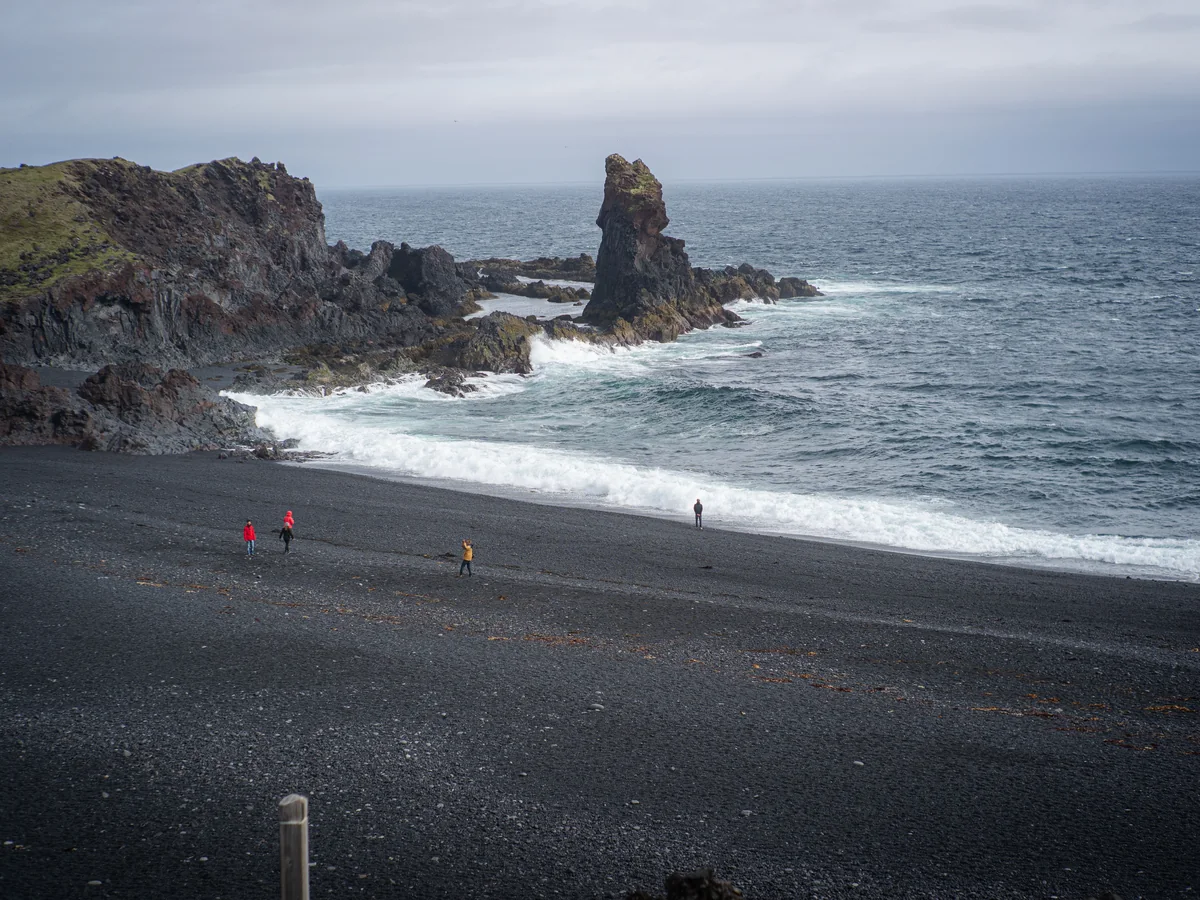A black-pebble Icelandic beach with a sea stack rock formation, representative of Djupalonssandur